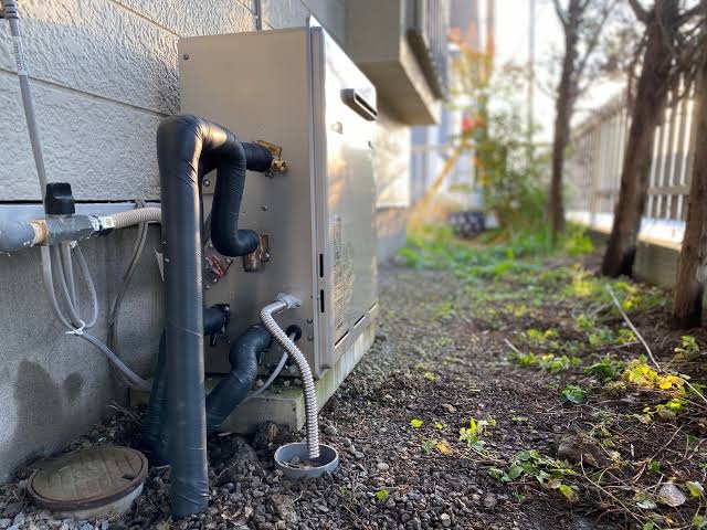 屋外設置の給湯器と保温施工