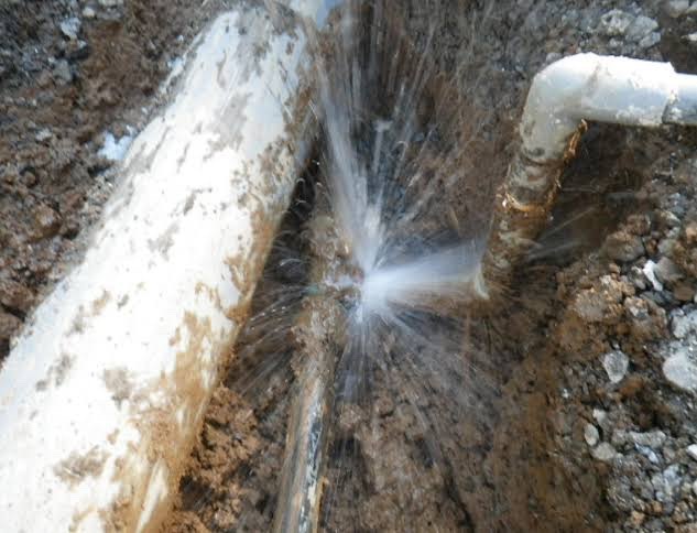 破裂した地中配管から水が噴き出している写真